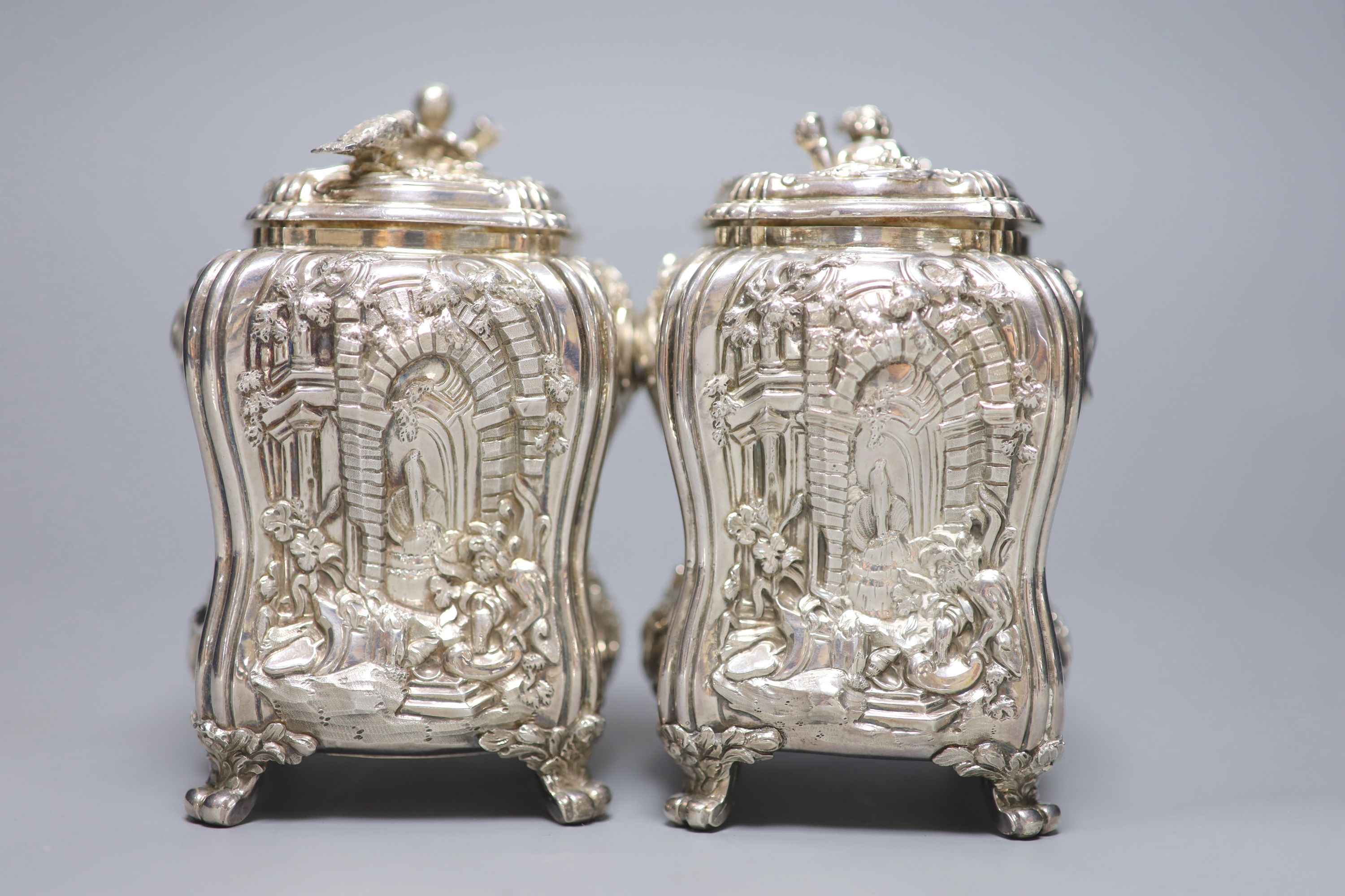 A good pair of George II embossed silver tea caddies and covers, by Elizabeth Godfrey, London, 1749/50, housed in a later 19th century pierced Canton ivory mounted caddy, with velvet interior